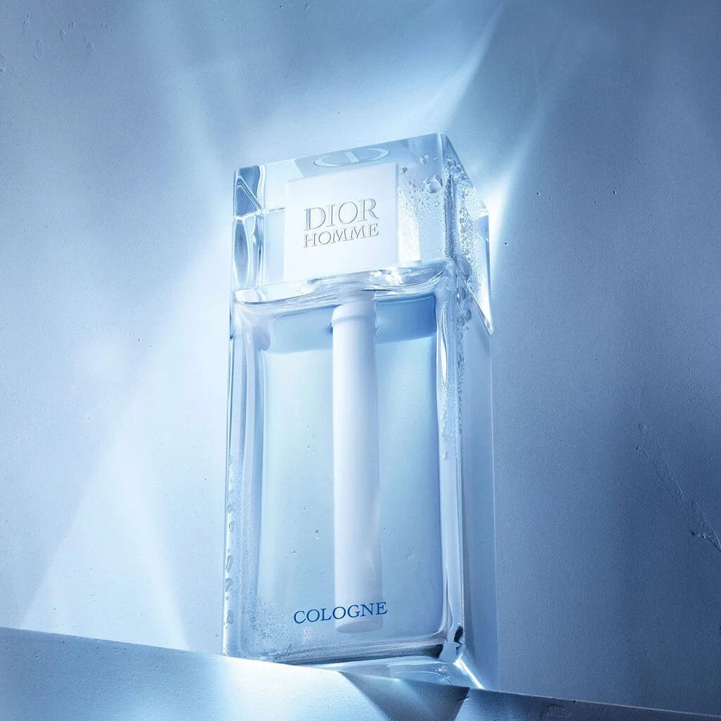 Dior Homme cologne bottle on a reflective blue surface