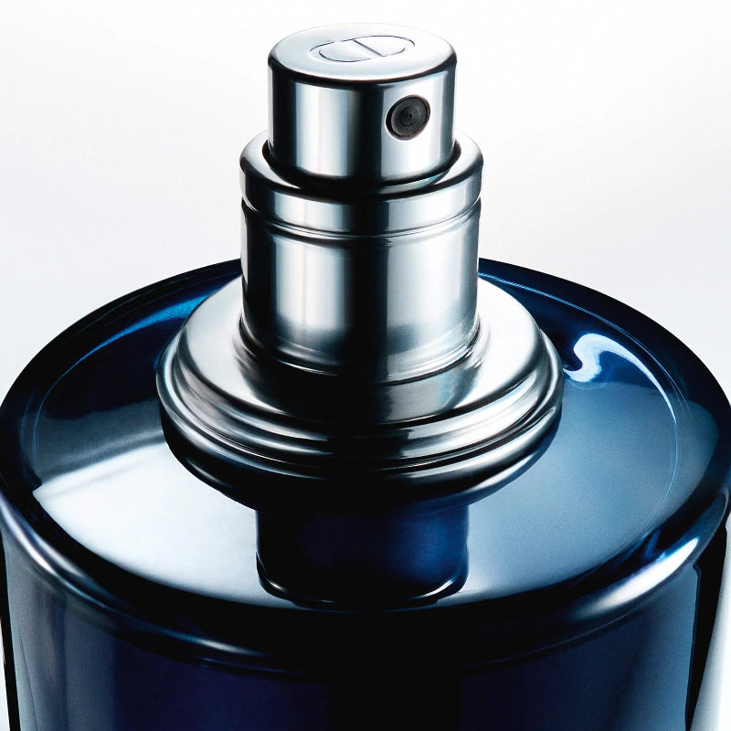 Blue perfume bottle with silver nozzle on a light blue background