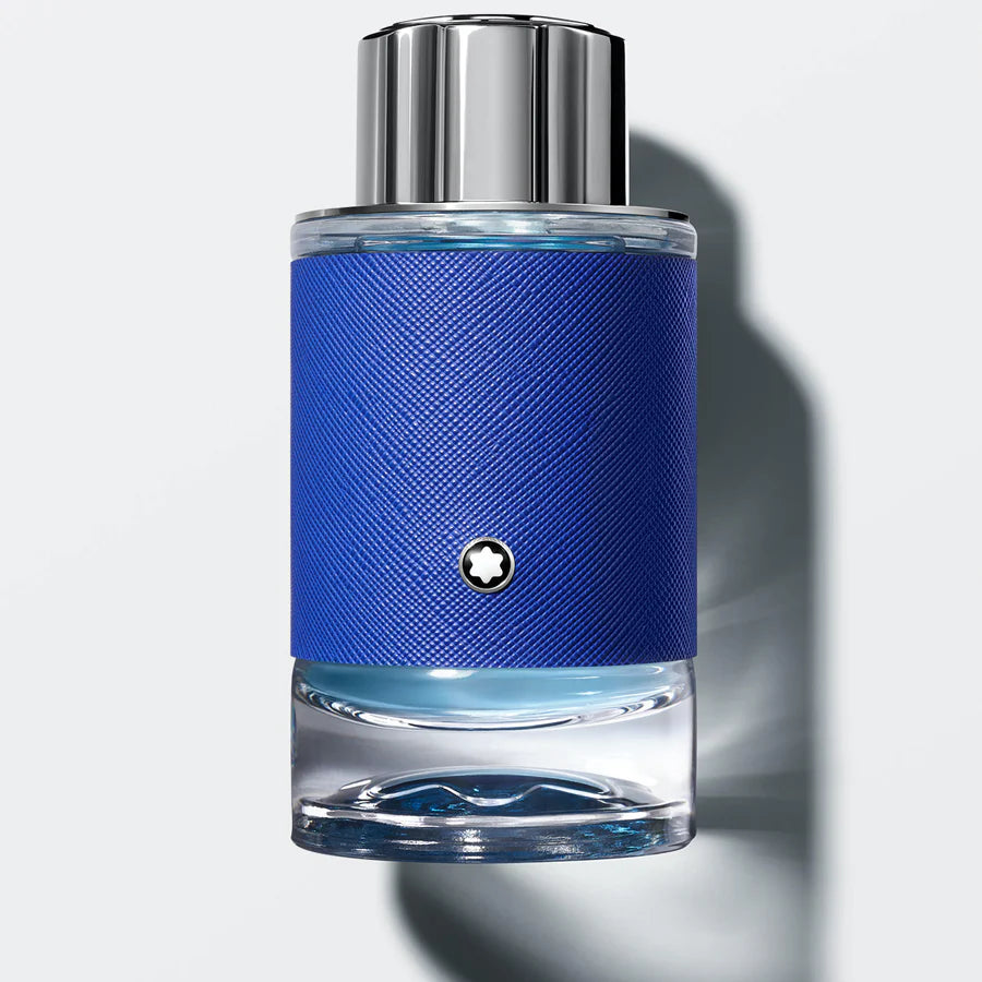Blue perfume bottle with silver cap on a light gray background