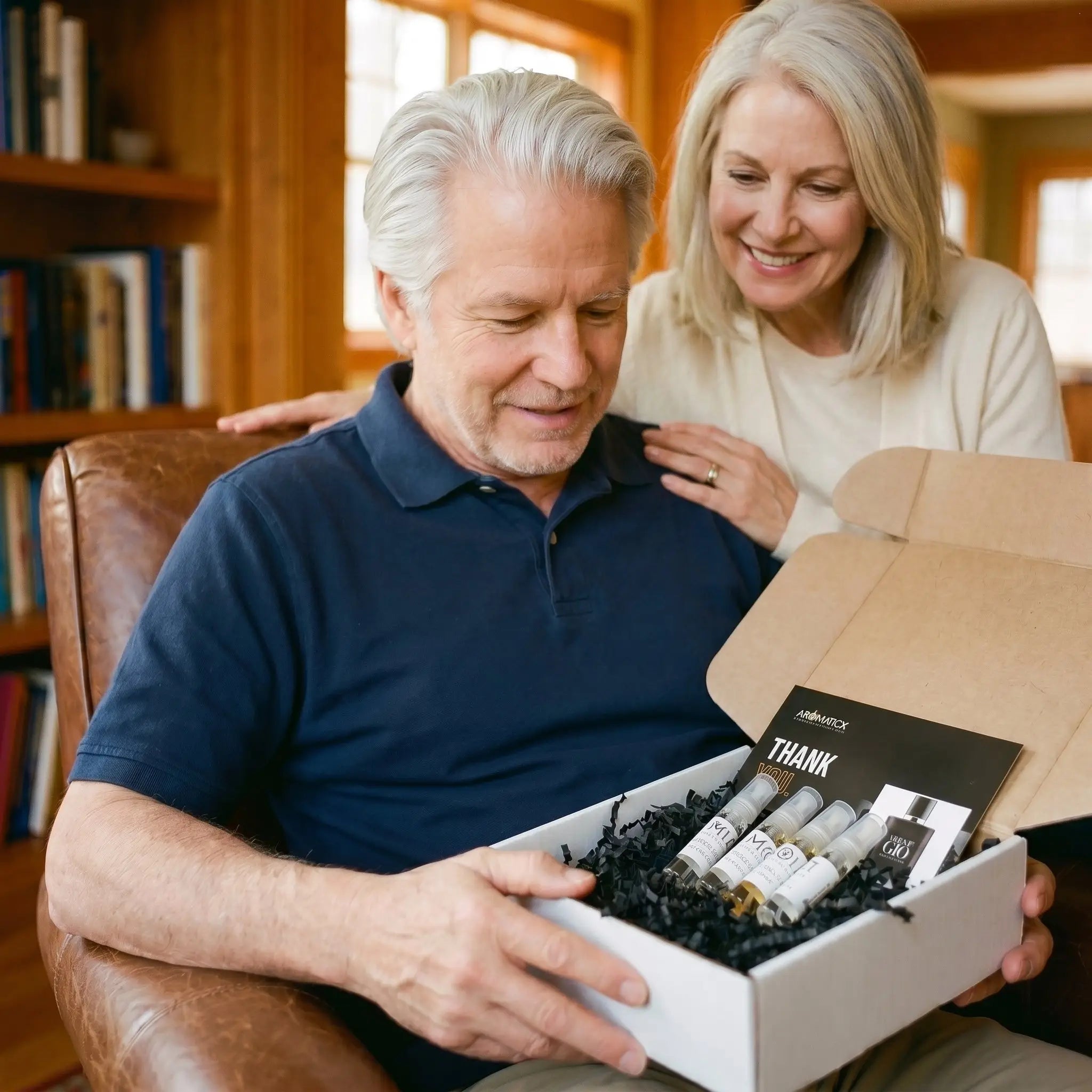 Older couple Father's Day — husband opening Aromatick fragrance decant bundle in leather armchair