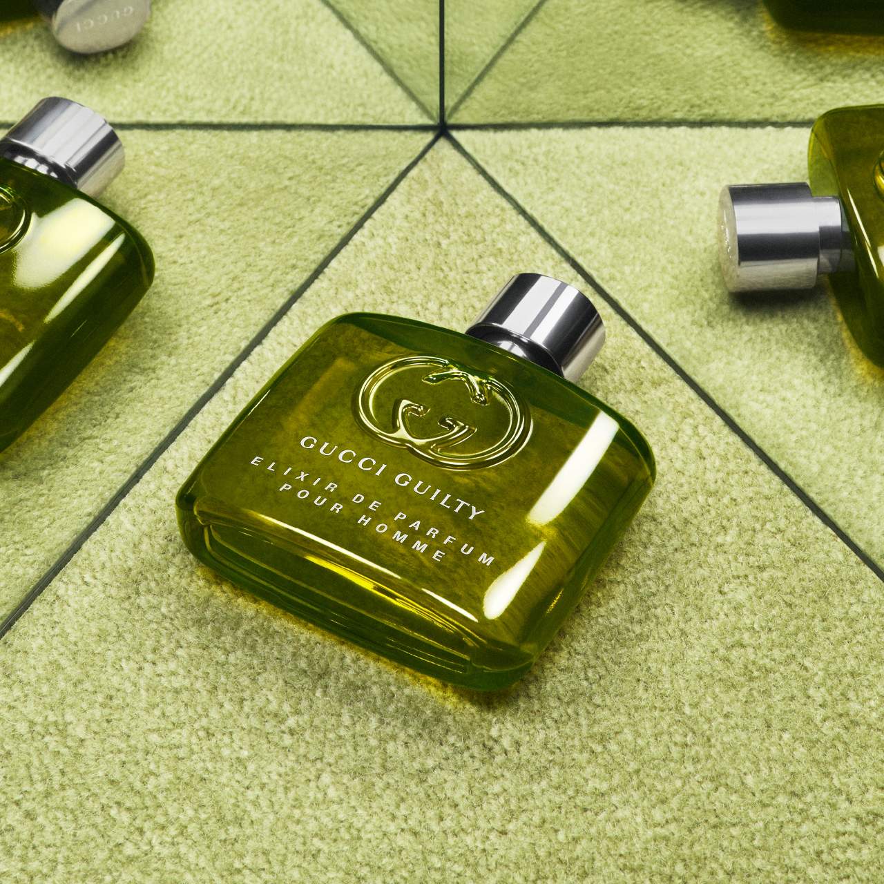 Green Gucci Quilty perfume bottle on a green checkered surface