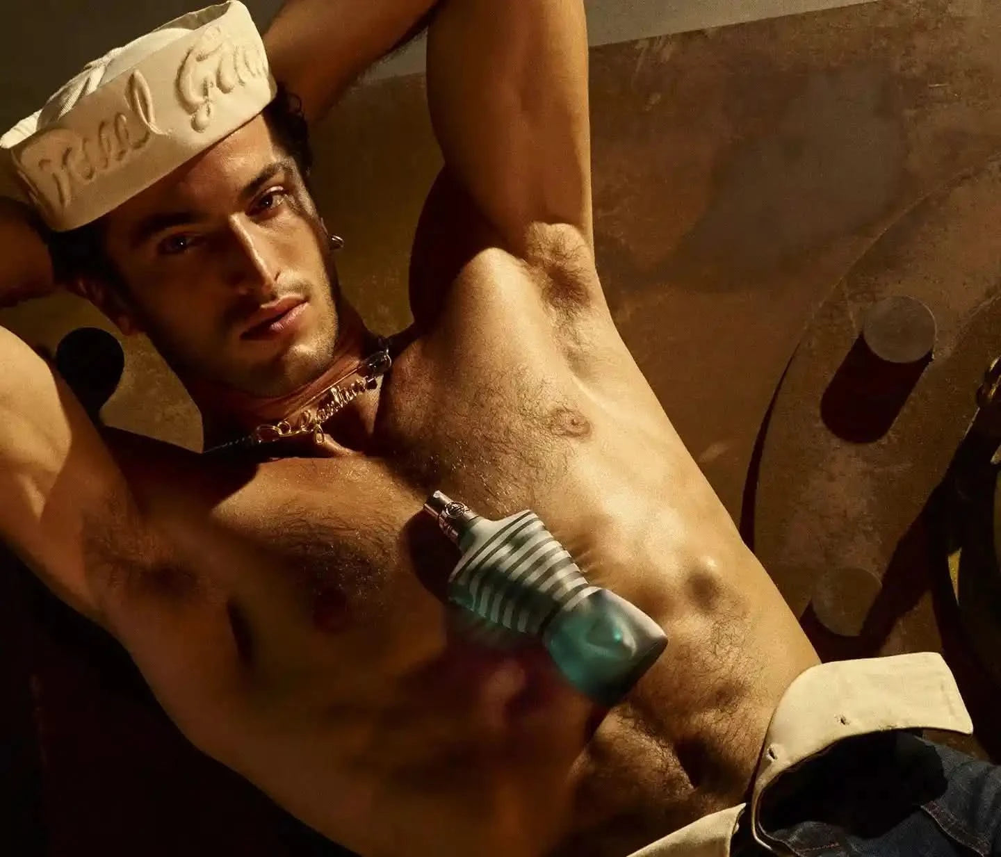 Jean Paul Gaultier Le Male EDT 4.2 oz featured on a shirtless male model, highlighting the sensual and masculine appeal of the fragrance.