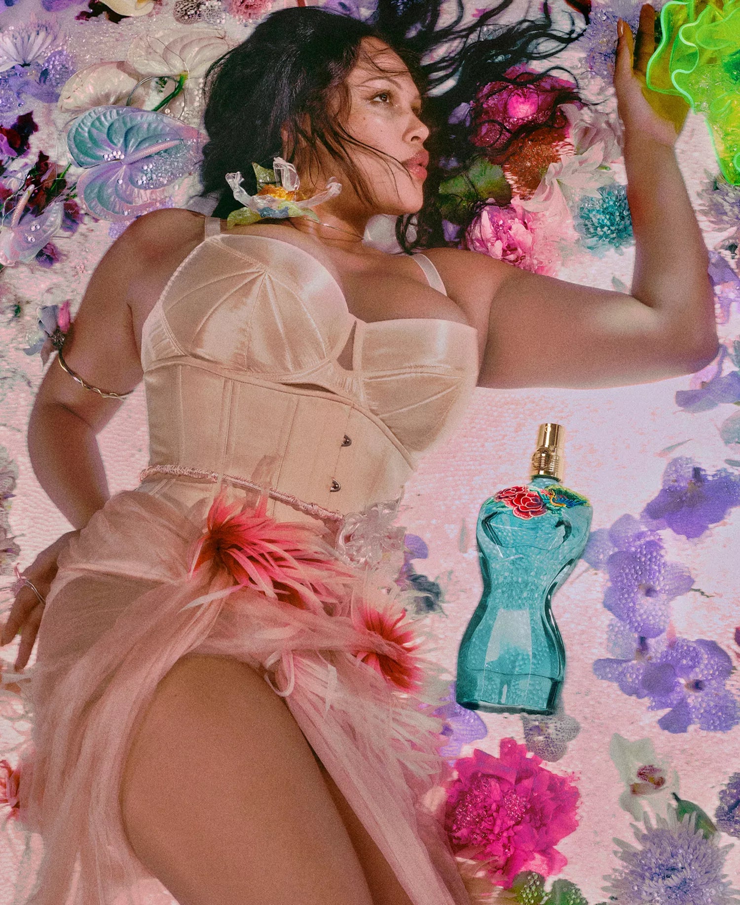 Jean Paul Gaultier La Belle Paradise Garden EDP campaign featuring turquoise corset bottle with embroidered floral detail in vibrant botanical setting