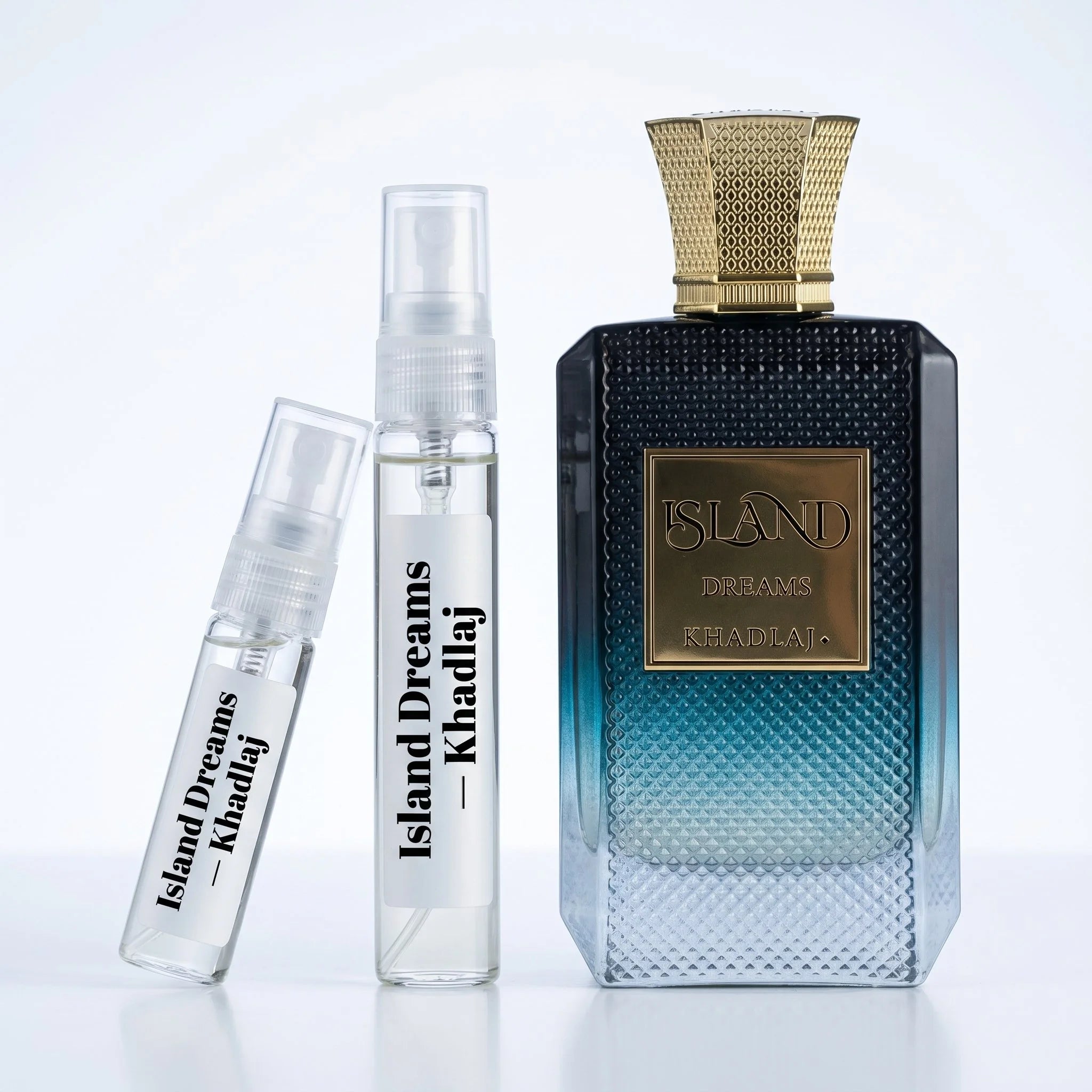 Khadlaj Island Dreams decant vials with navy teal gradient diamond textured bottle on white background luxury fragrance photography