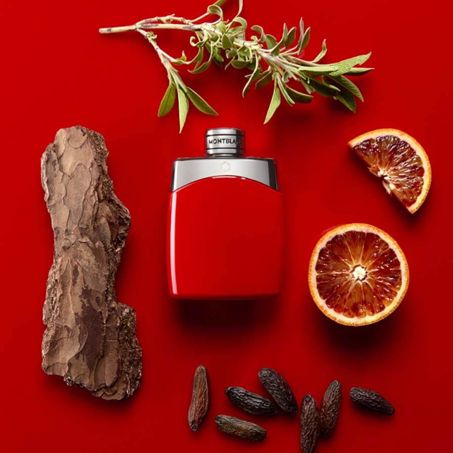 Red perfume bottle with natural elements on a red background