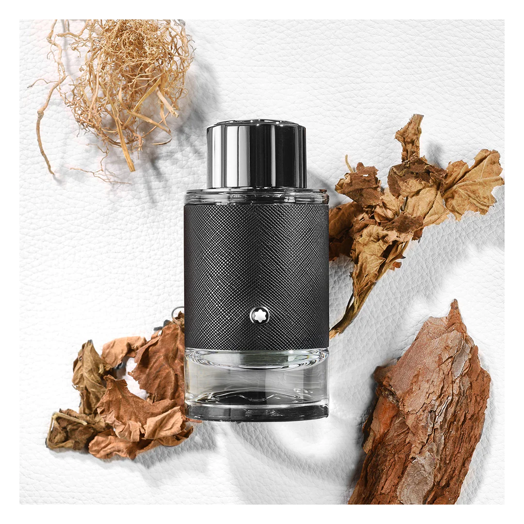 Black and silver cylindrical product with natural elements on a white background