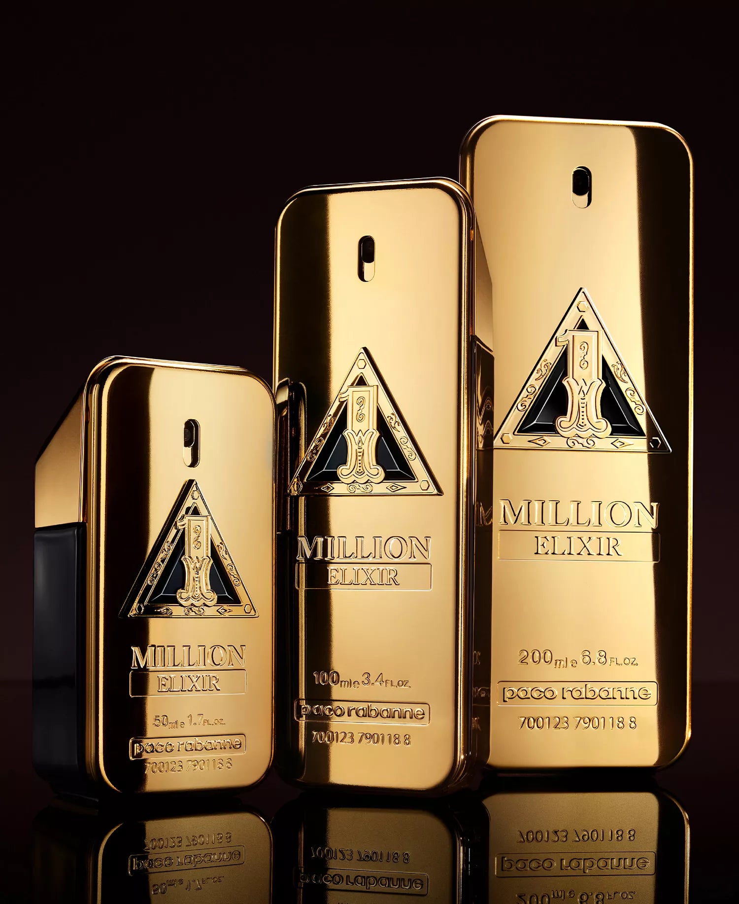 Three gold perfume bottles labeled 'Milion Elixir' by Paco Rabanne on a reflective surface with a dark background.