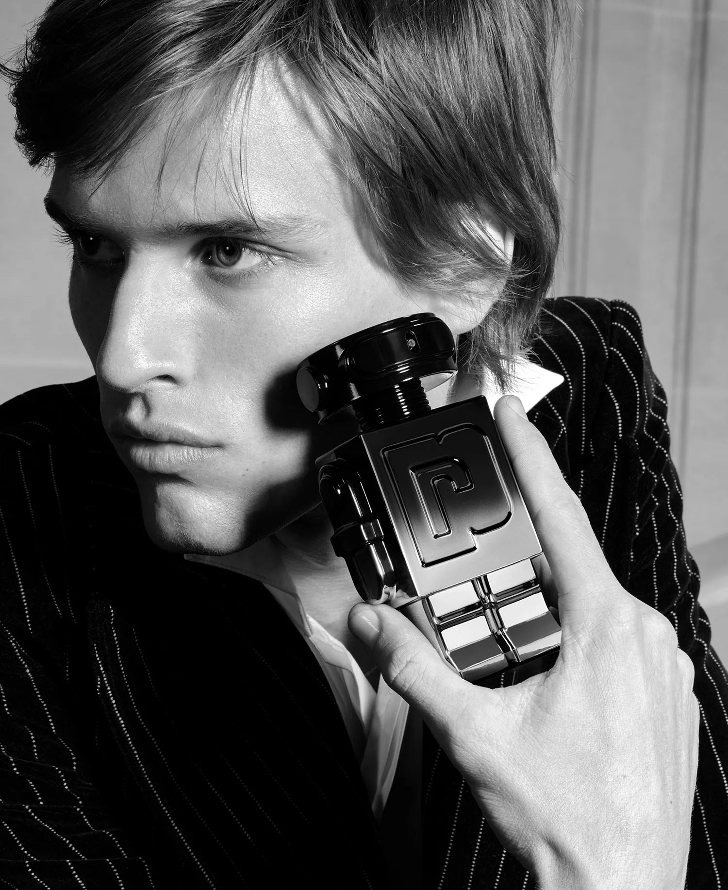 Person holding a Chanel perfume bottle in black and white.