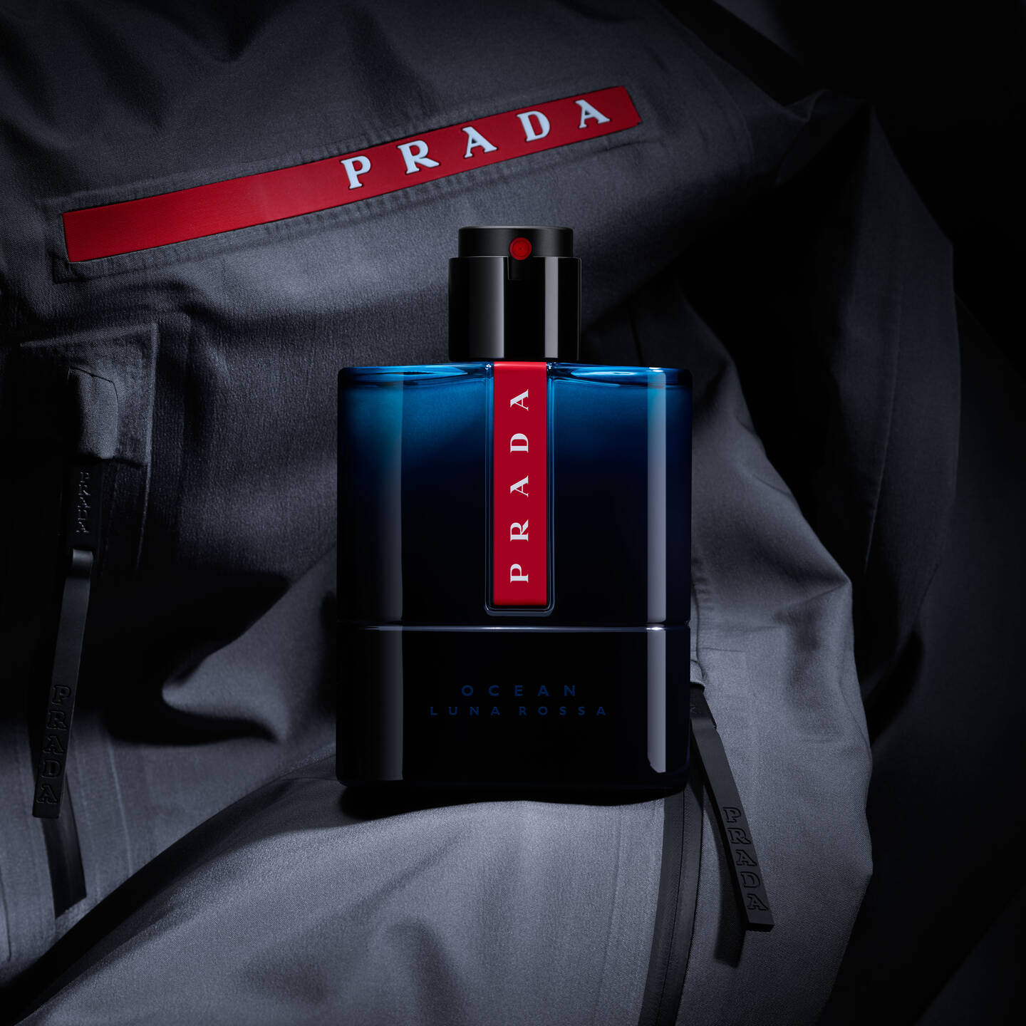 Prada perfume bottle on a dark fabric background
