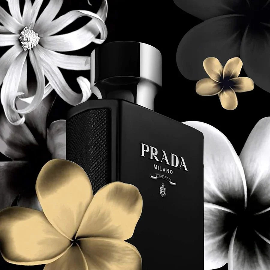Black Prada Milano perfume bottle surrounded by flowers on a black background