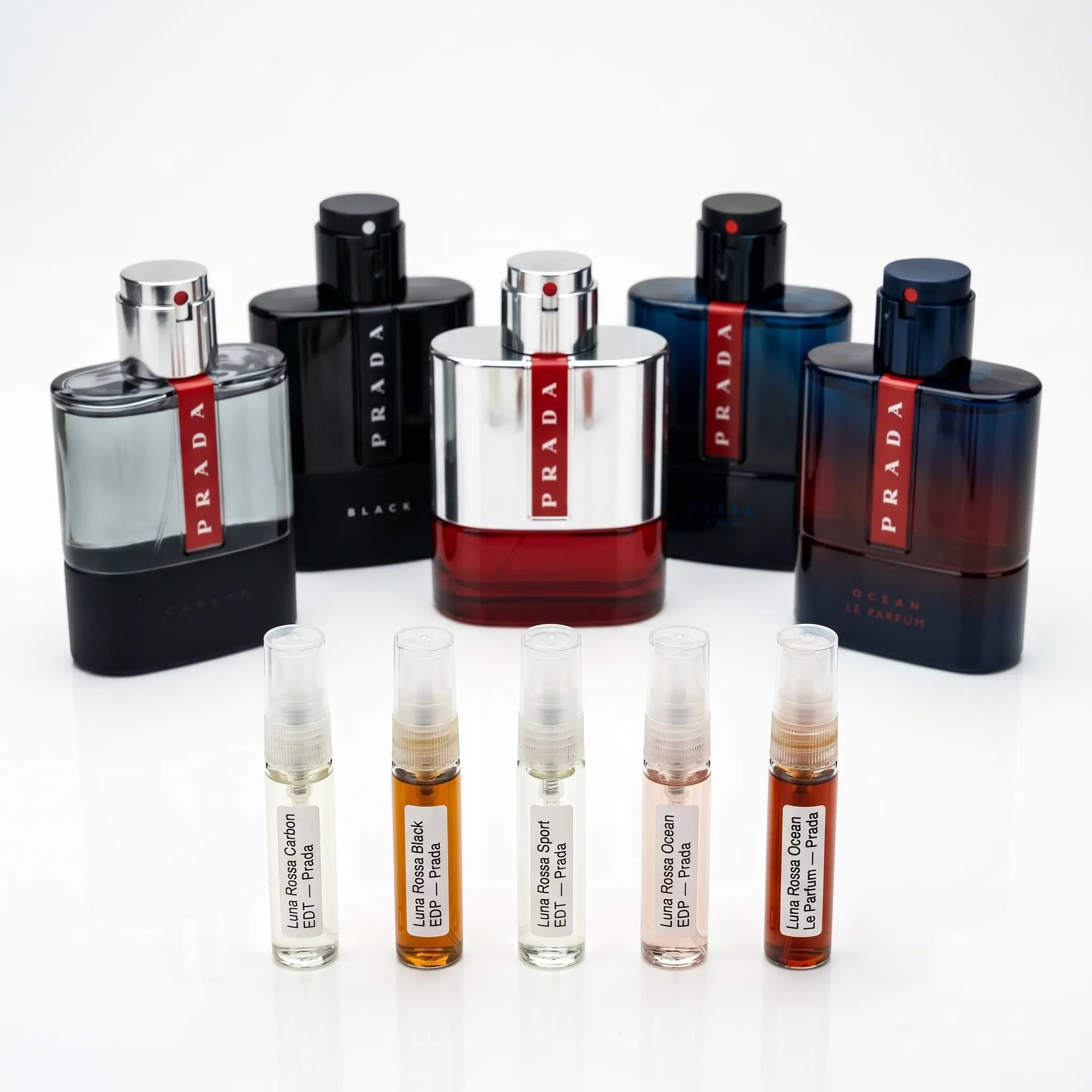 Prada Luna Rossa Discovery Set hero — Carbon, Black, Sport, Ocean EDP and Le Parfum bottles with decants
