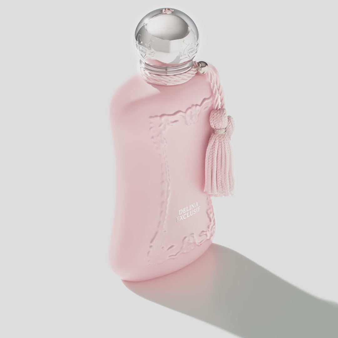 Angled view of PDM Delina Exclusif EDP pink perfume bottle casting a shadow, highlighting its feminine design and floral oriental scent.