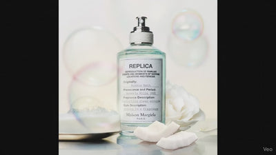 Maison Margiela Replica Bubble Bath EDT bottle with coconut slices, white rose, and soap bubbles, highlighting its clean, musky scent.
