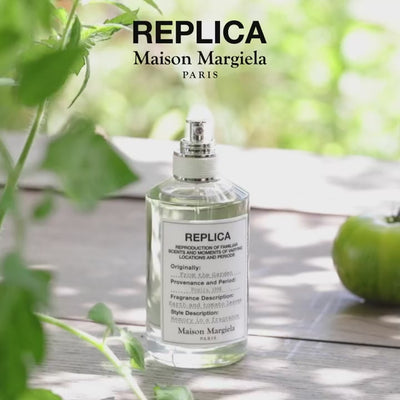 Maison Margiela Replica From the Garden EDT displayed outdoors on a wooden surface, highlighting its fresh, green unisex scent.