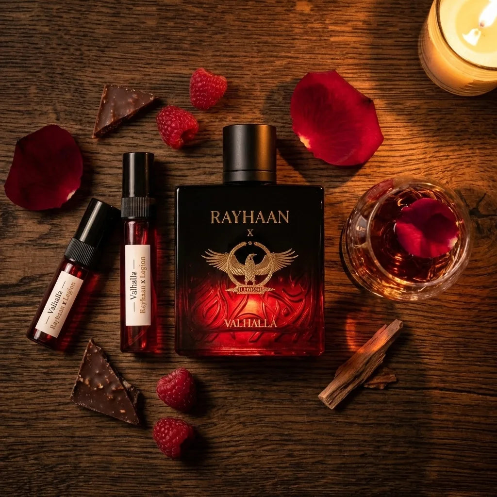 Perfume bottles with 'RAYHAAN' branding on a wooden surface with raspberries and rose petals.