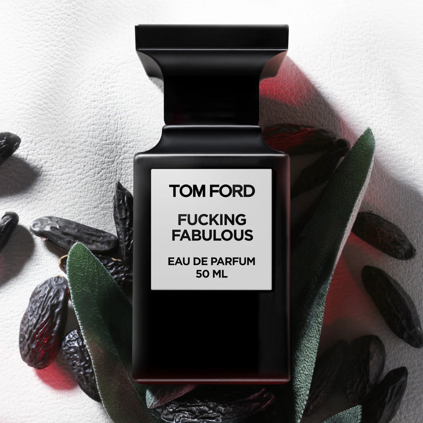 Tom Ford Fucking Fabulous perfume bottle with dried fruits and leaves on a light background