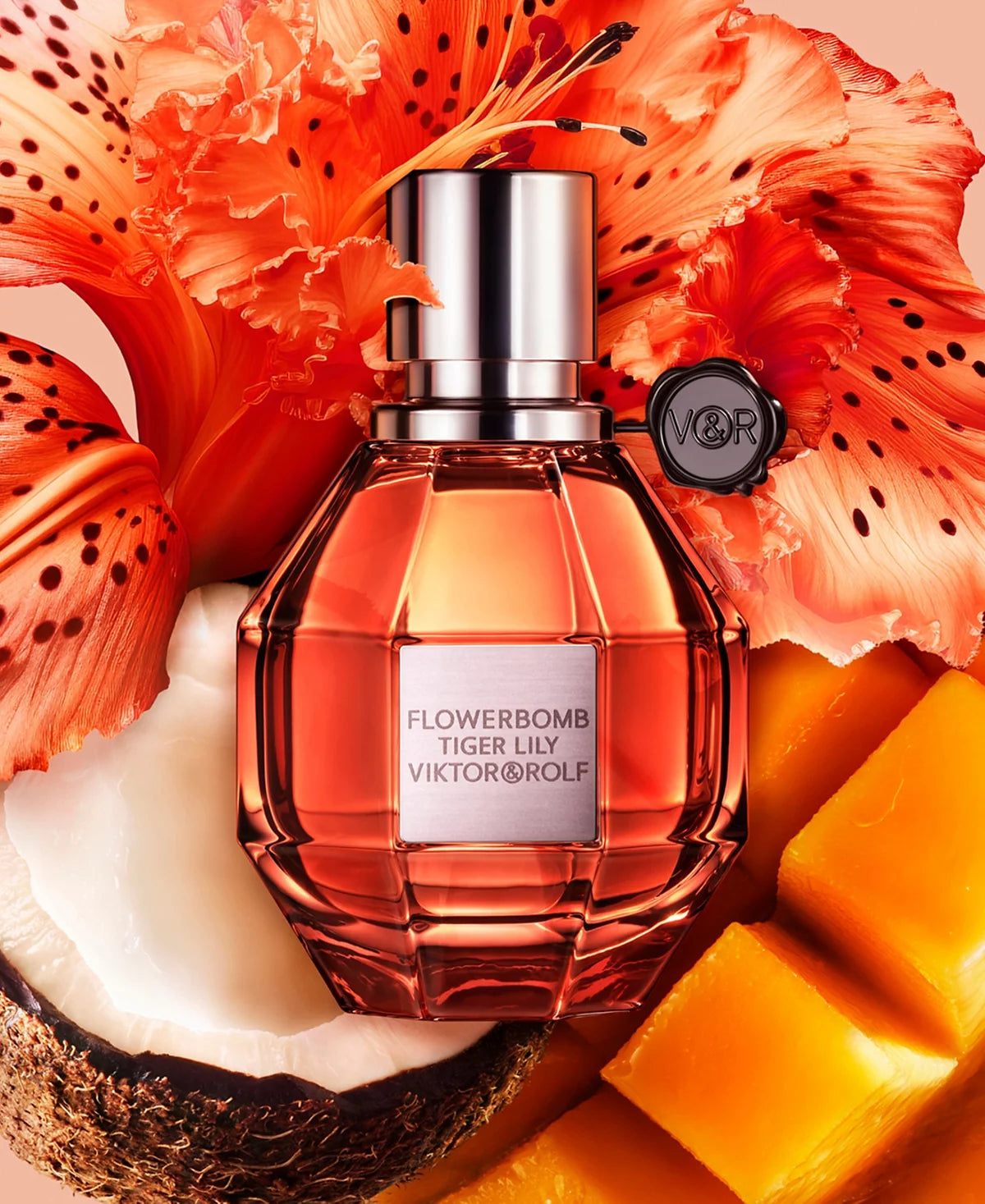 Viktor & Rolf Flowerbomb Tiger Lily perfume bottle with orange flowers and fruit on a beige background