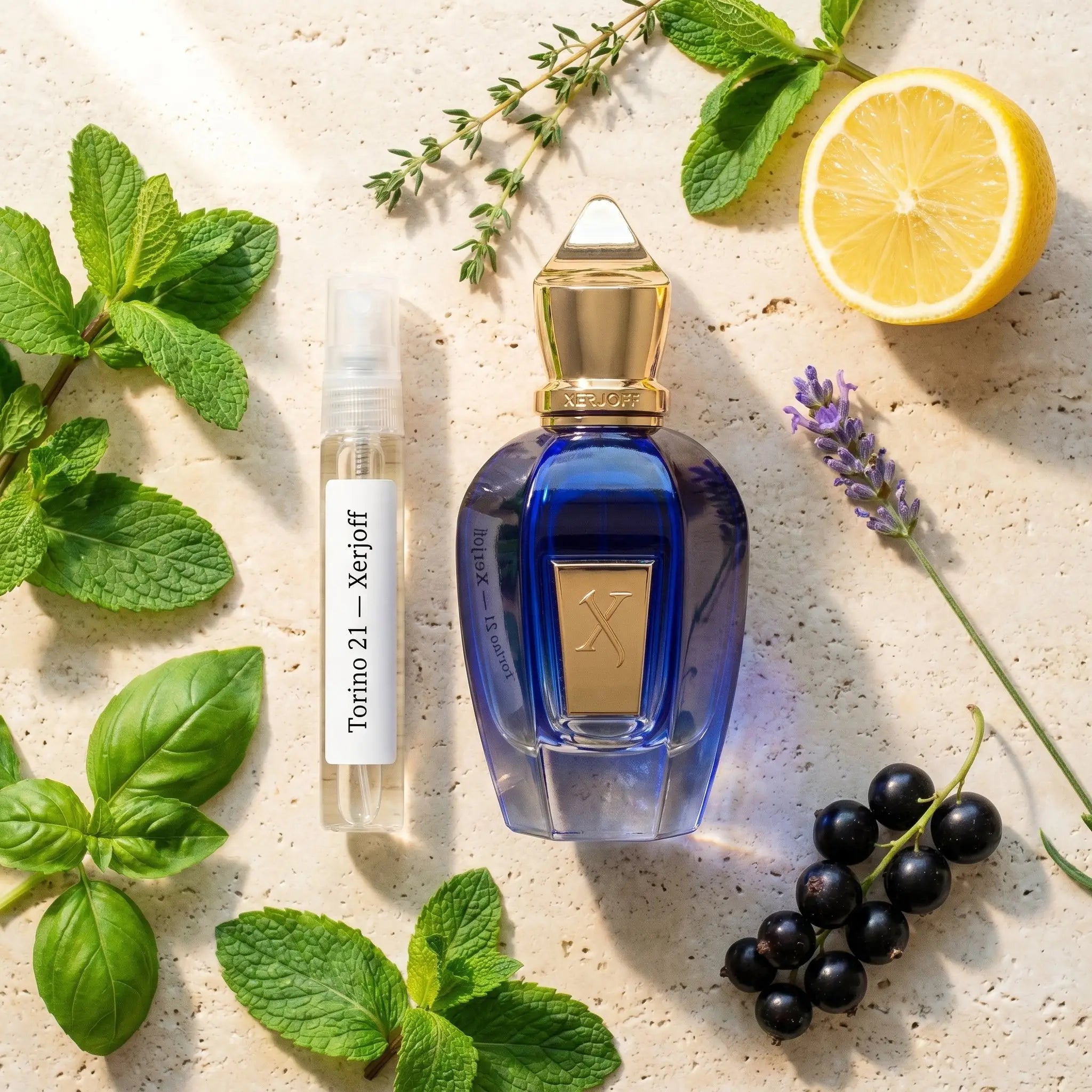 Xerjoff Torino 21 bottle and decant on Italian stone with mint lemon basil jasmine lavender fragrance notes flatlay