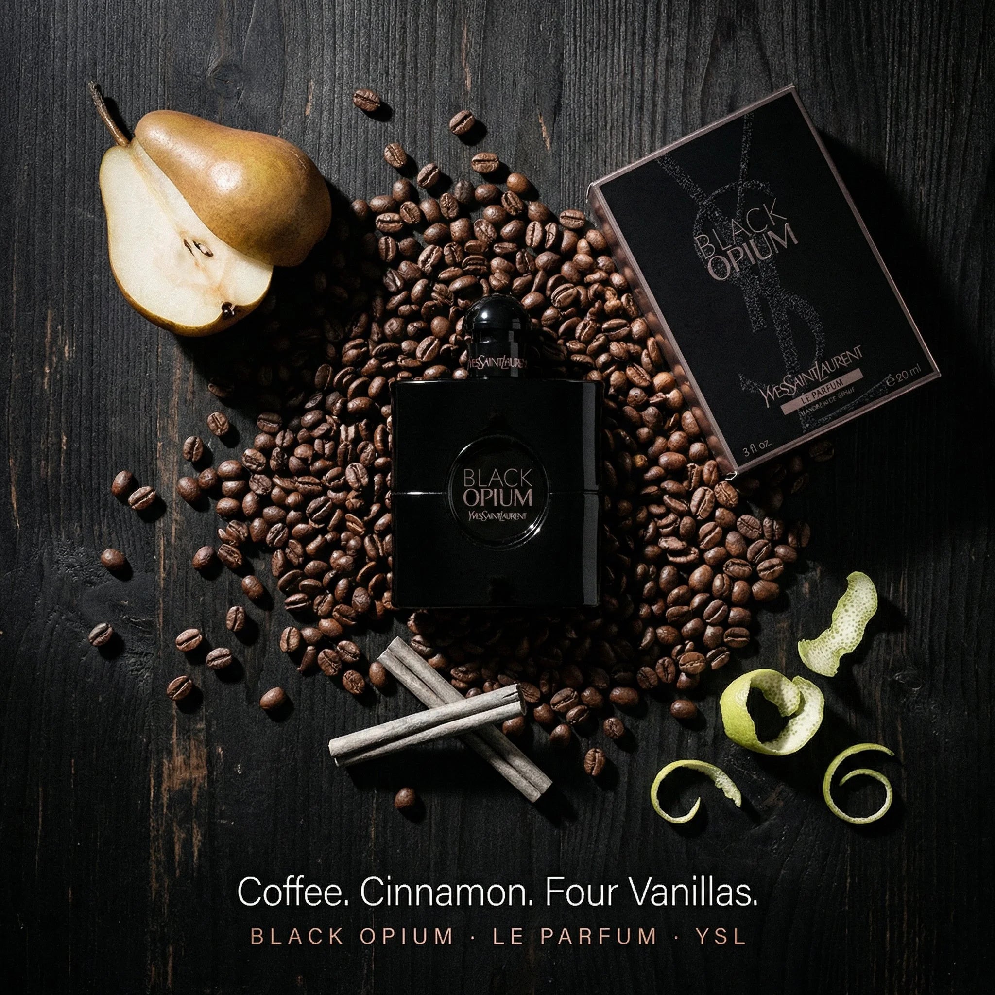 YSL Black Opium perfume surrounded by coffee beans, a pear, and cinnamon sticks on a dark surface.