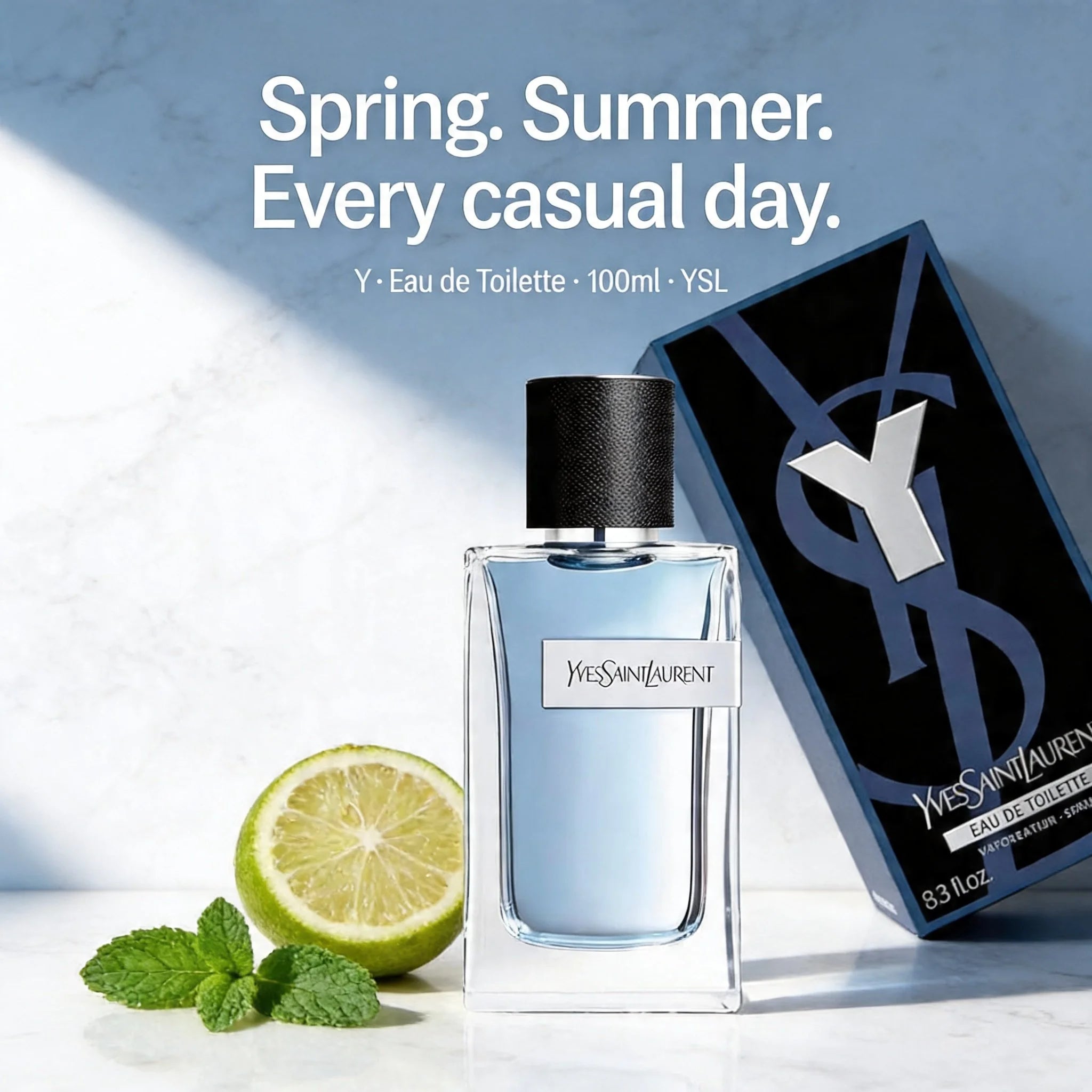 YSL perfume bottle with packaging and lime on a light background